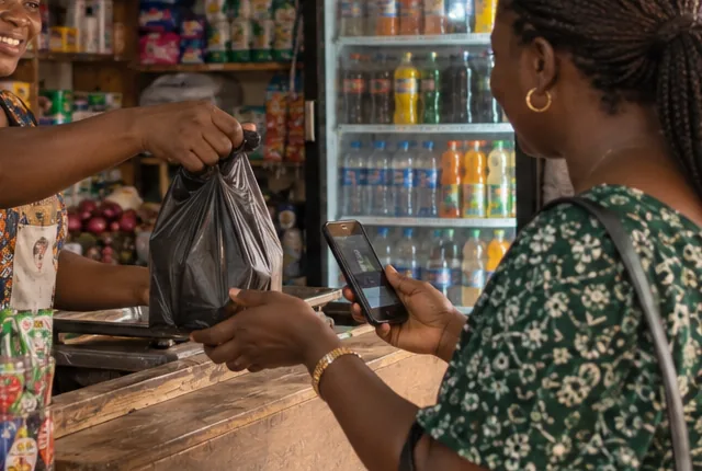 Une cliente règle ses achats au comptoir avec son téléphone